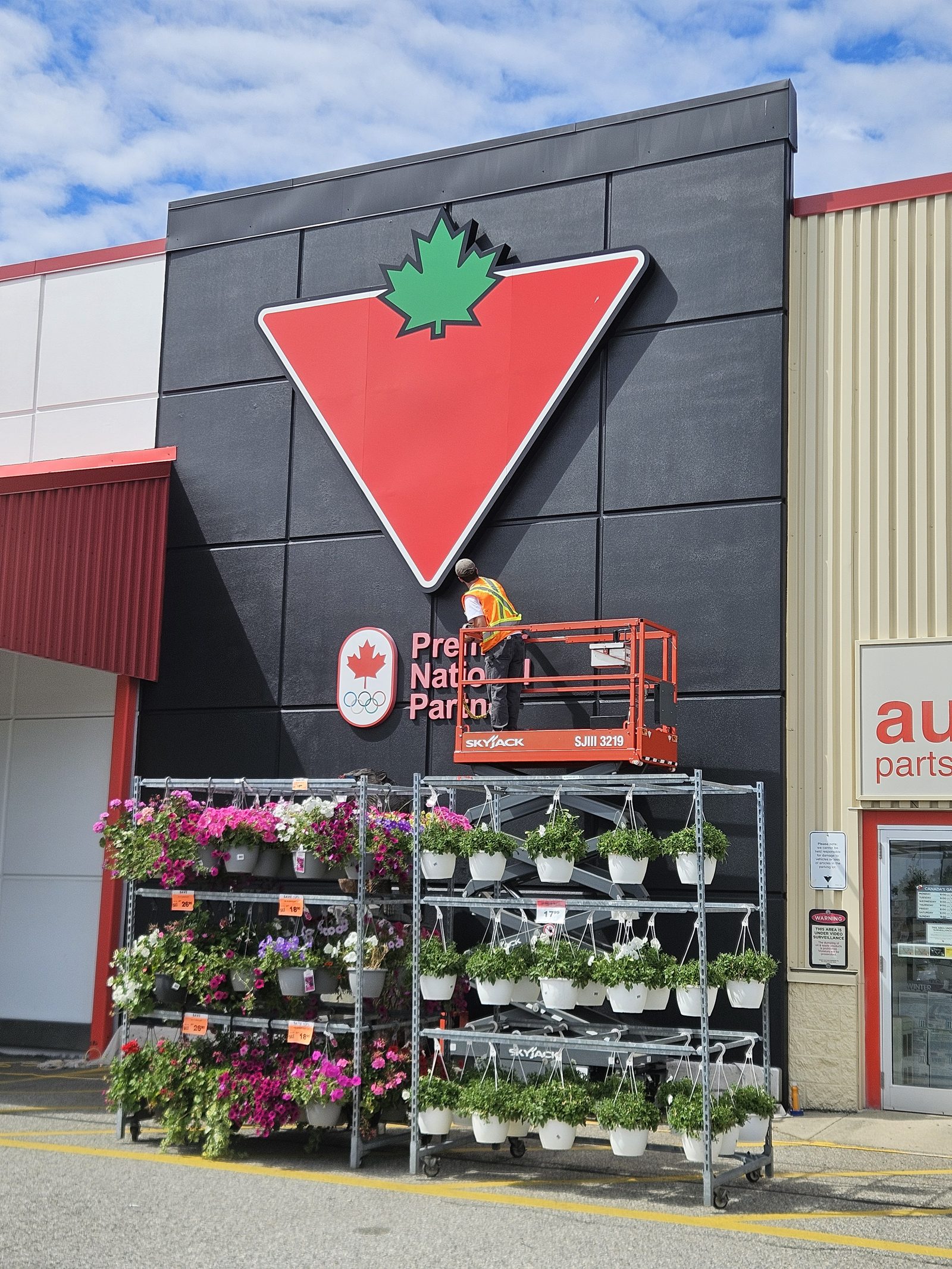 Exterior work from a scissor lift during an ownership changeover at a franchise location