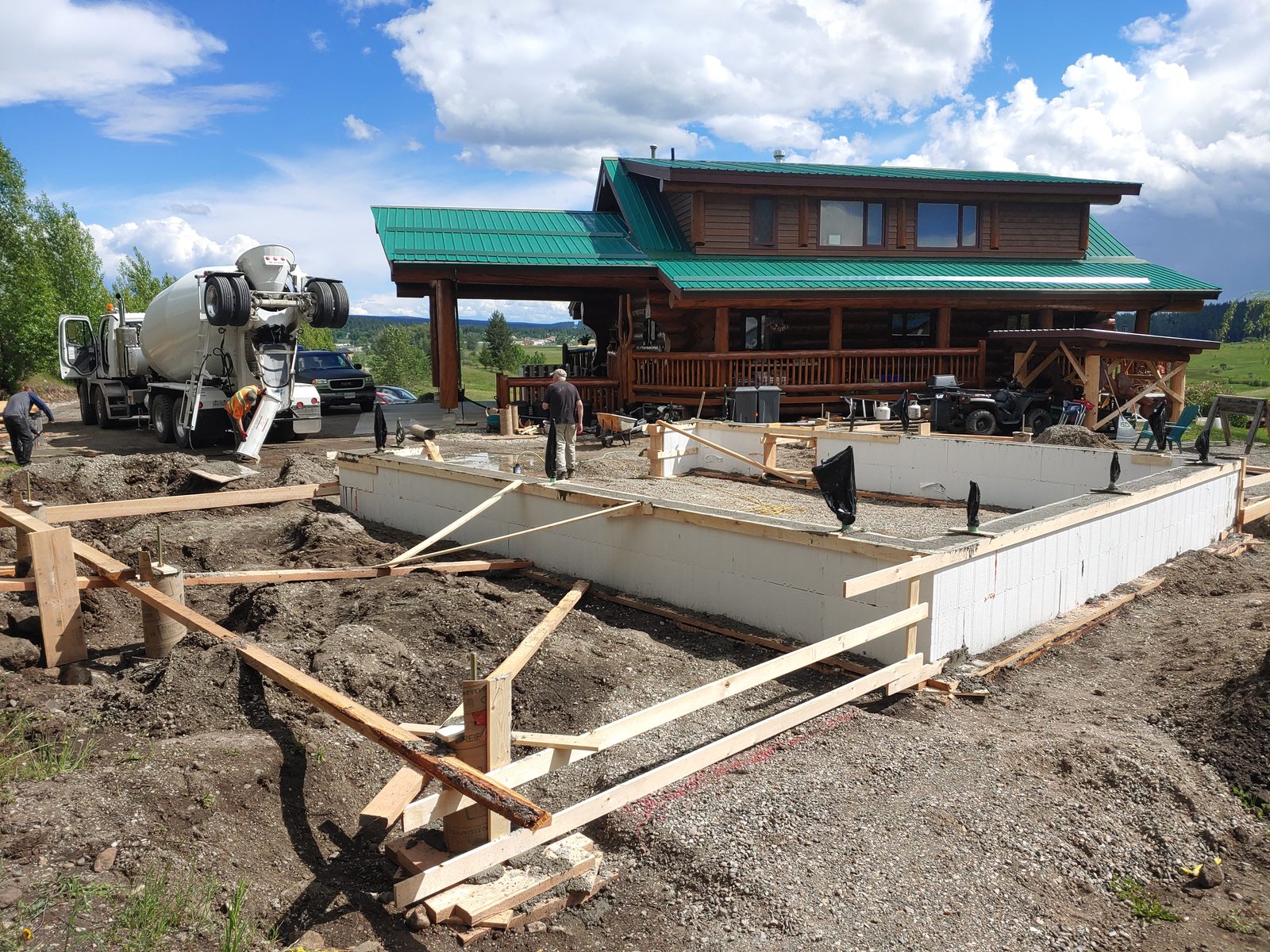 A concrete pour underway on an ICF wall and sonotube footings