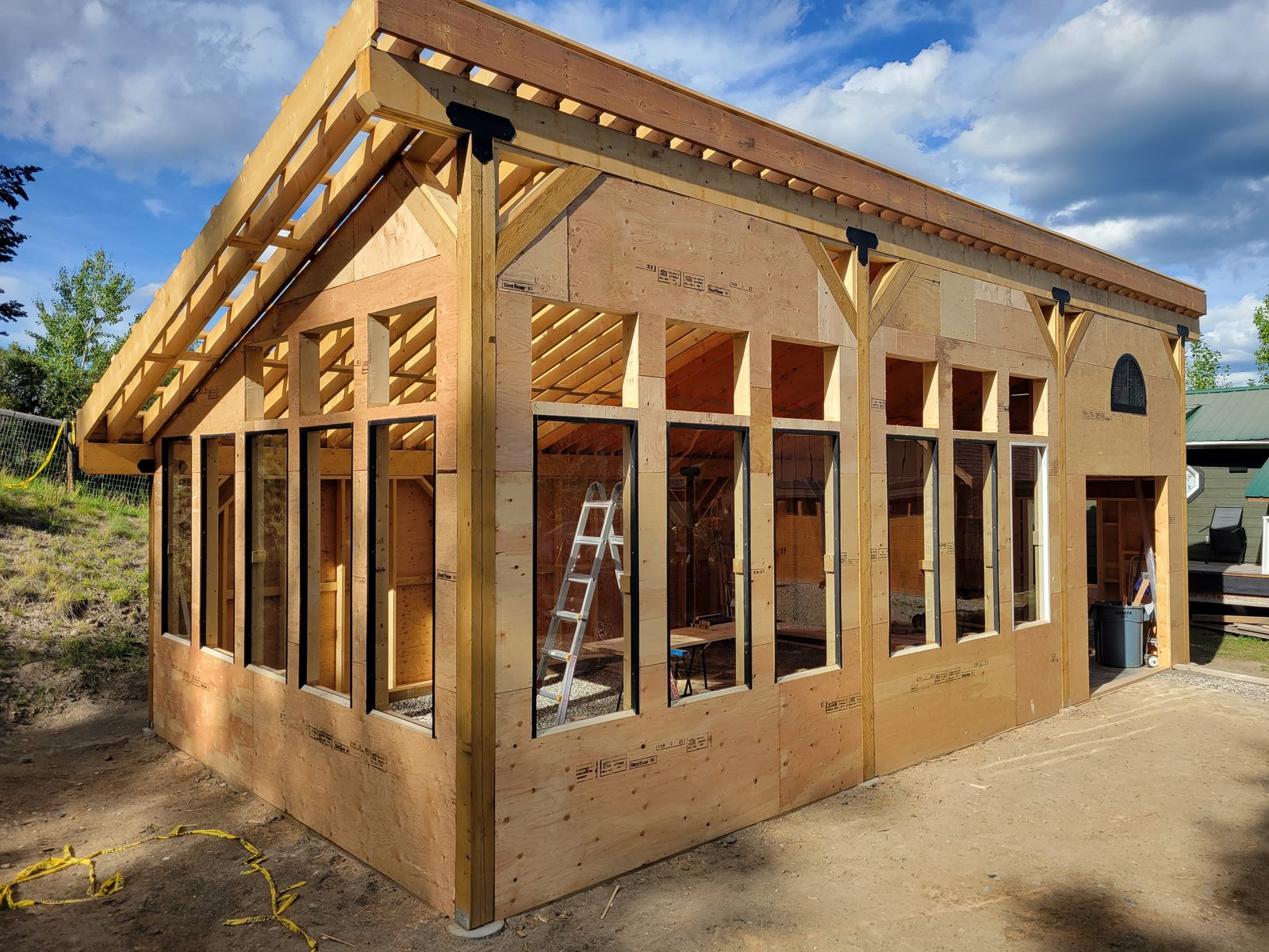 Exposed rafters and timber posts on a greenhouse under construction