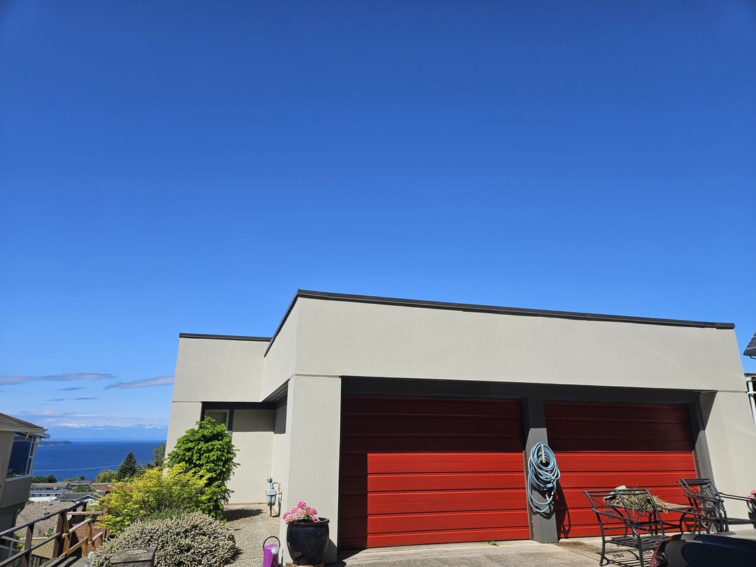 A contemporary home with red garage doors after an exterior colour change