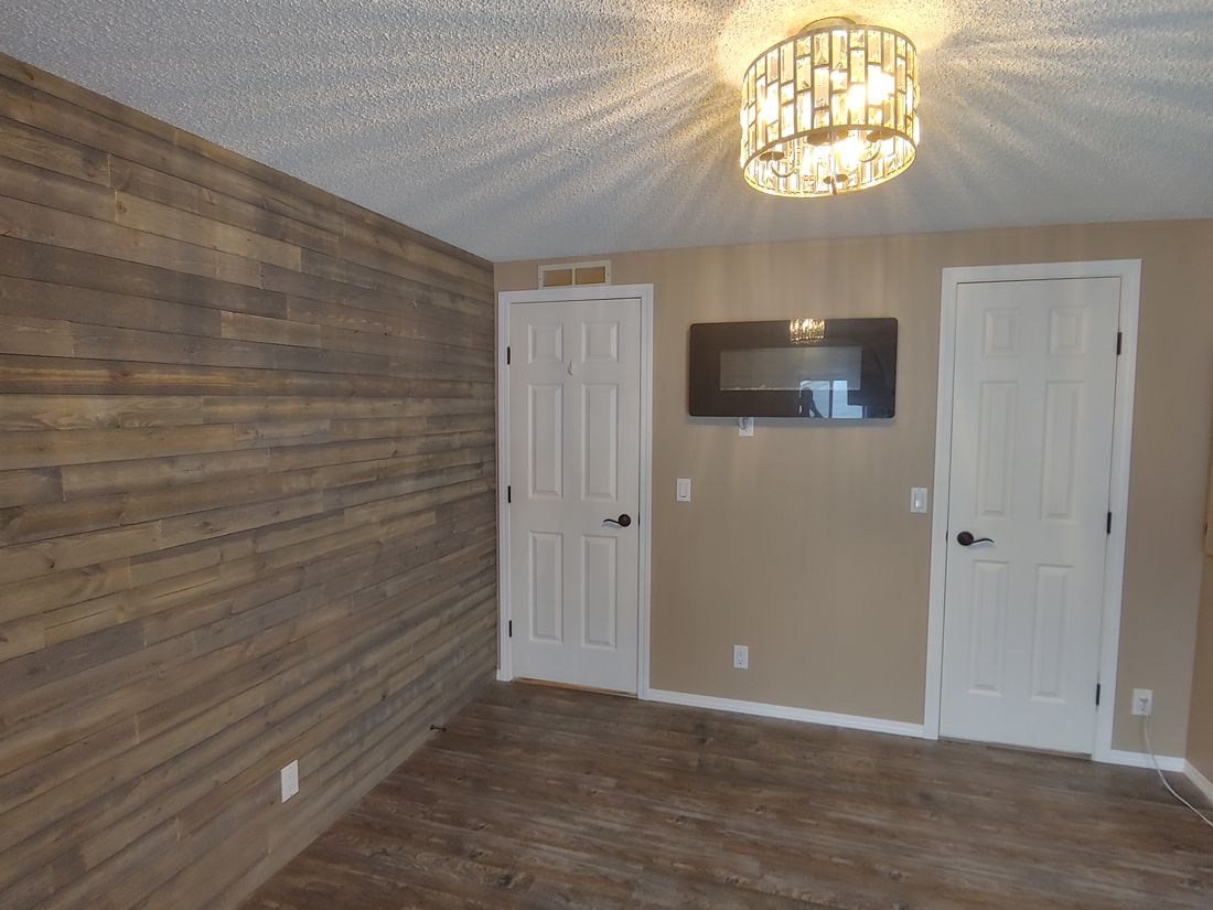 A repainted room with a stained shiplap accent wall in a Williams Lake mobile home