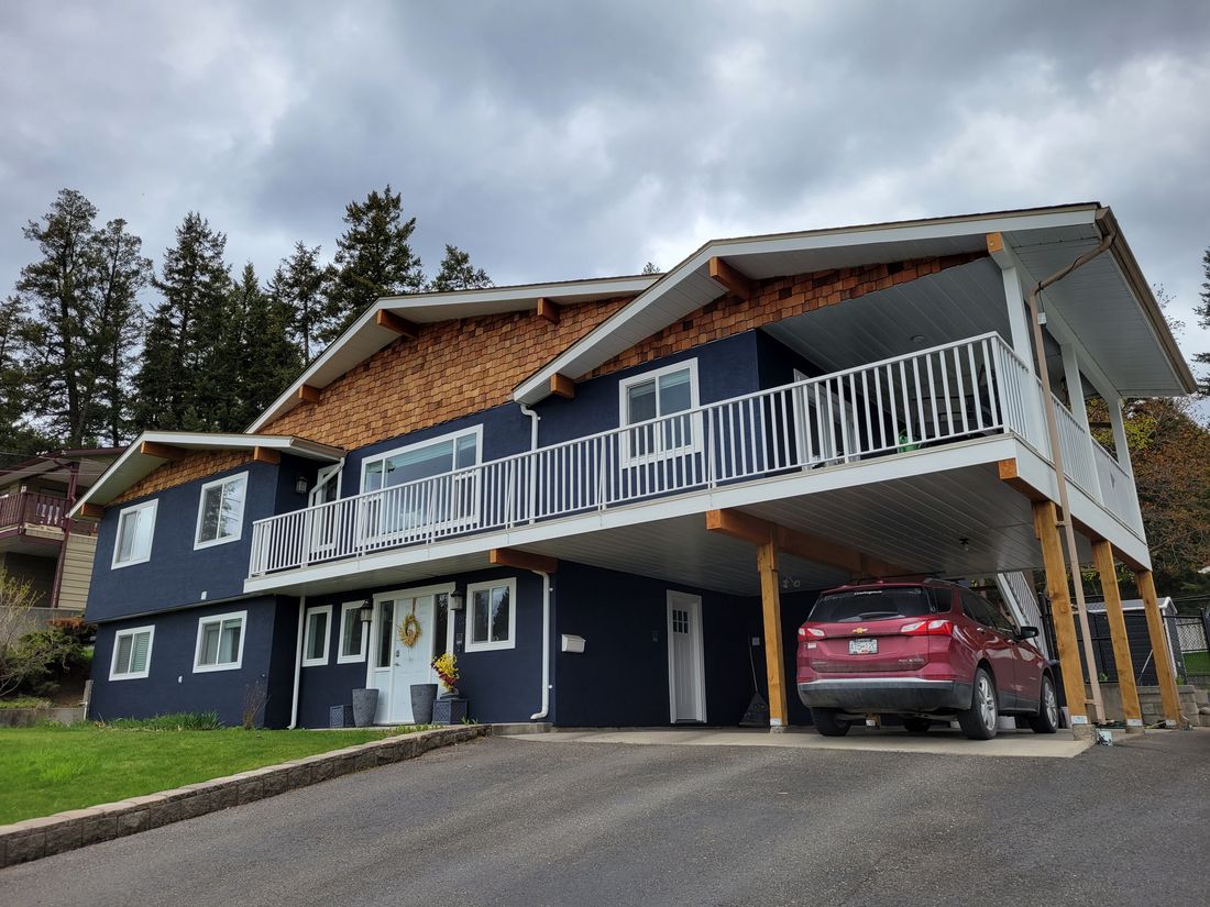 A home with cedar shake gables and stucco painted by brush