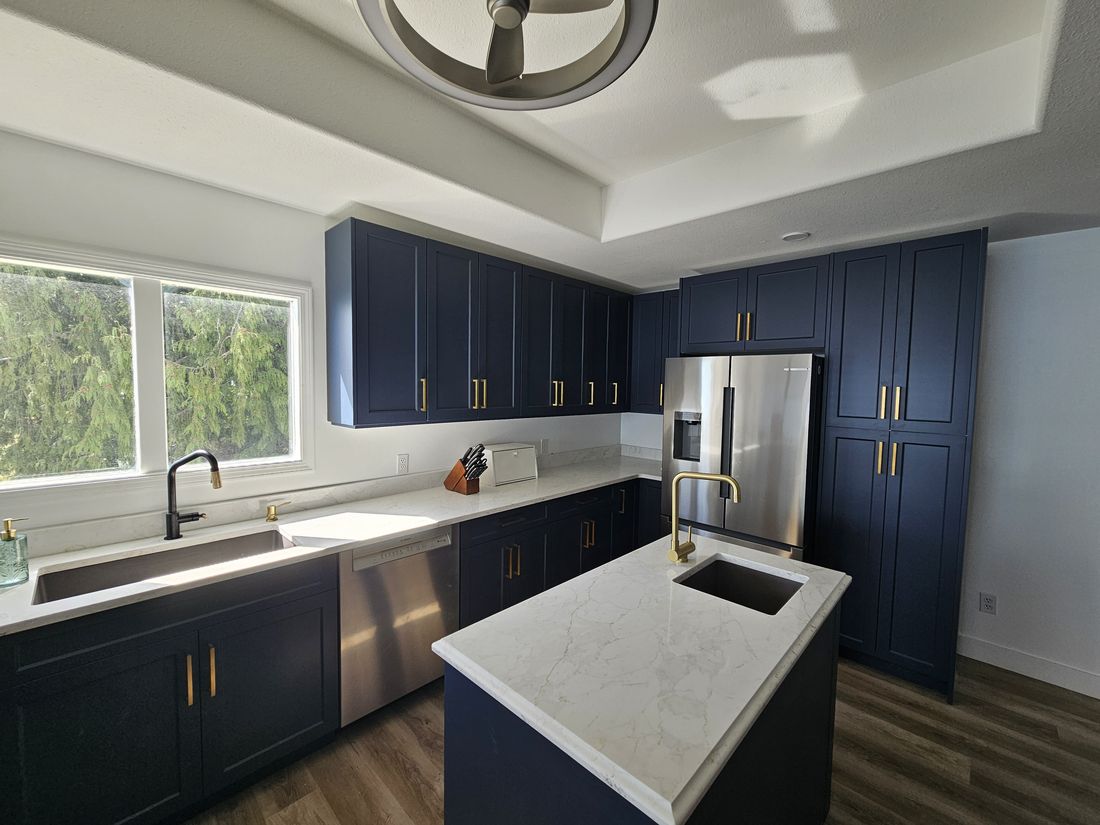 A navy kitchen with undermount sinks in quartz counters