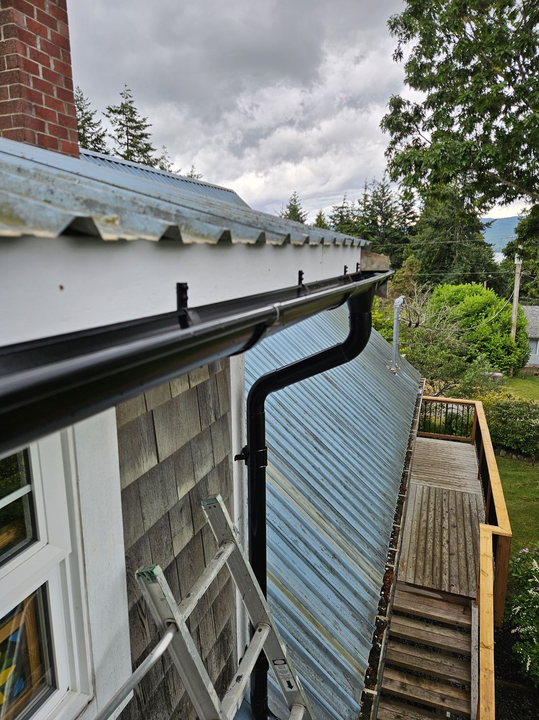 A European gutter system and downpipe on an older home