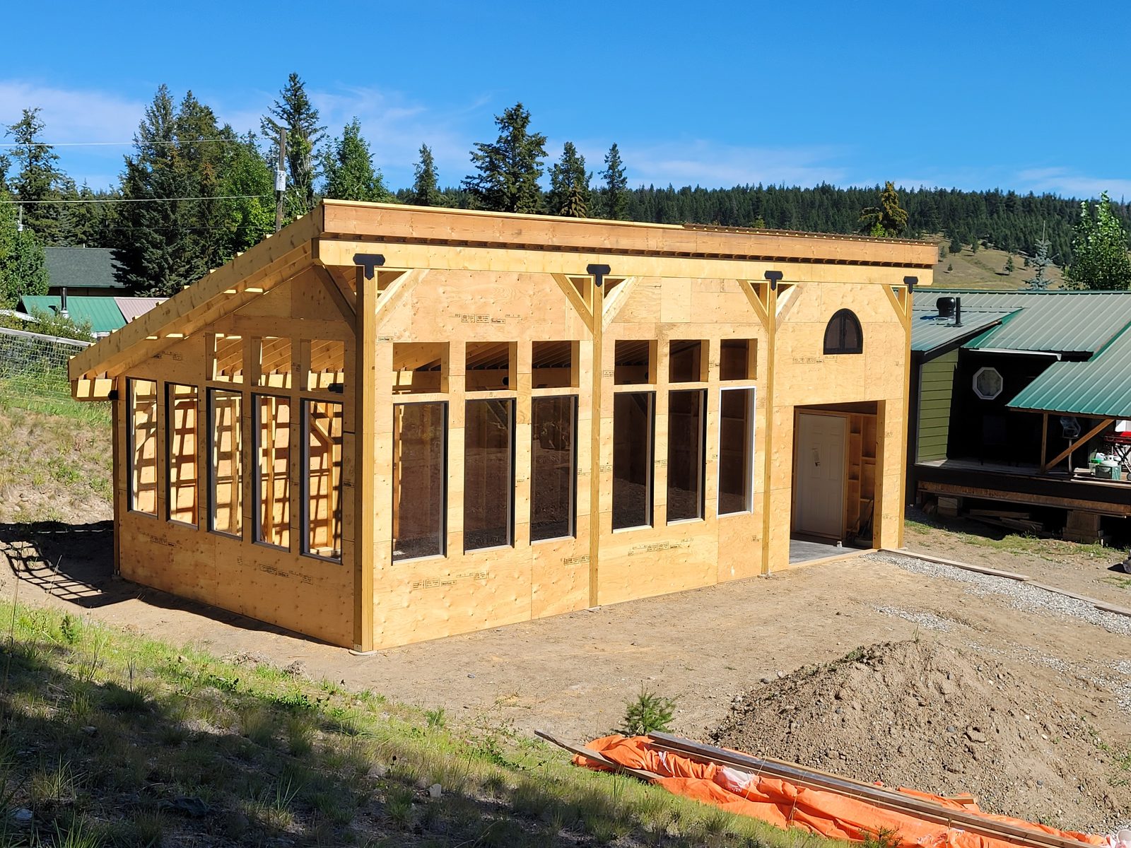 A custom greenhouse and she-shed under construction at Chimney Lake