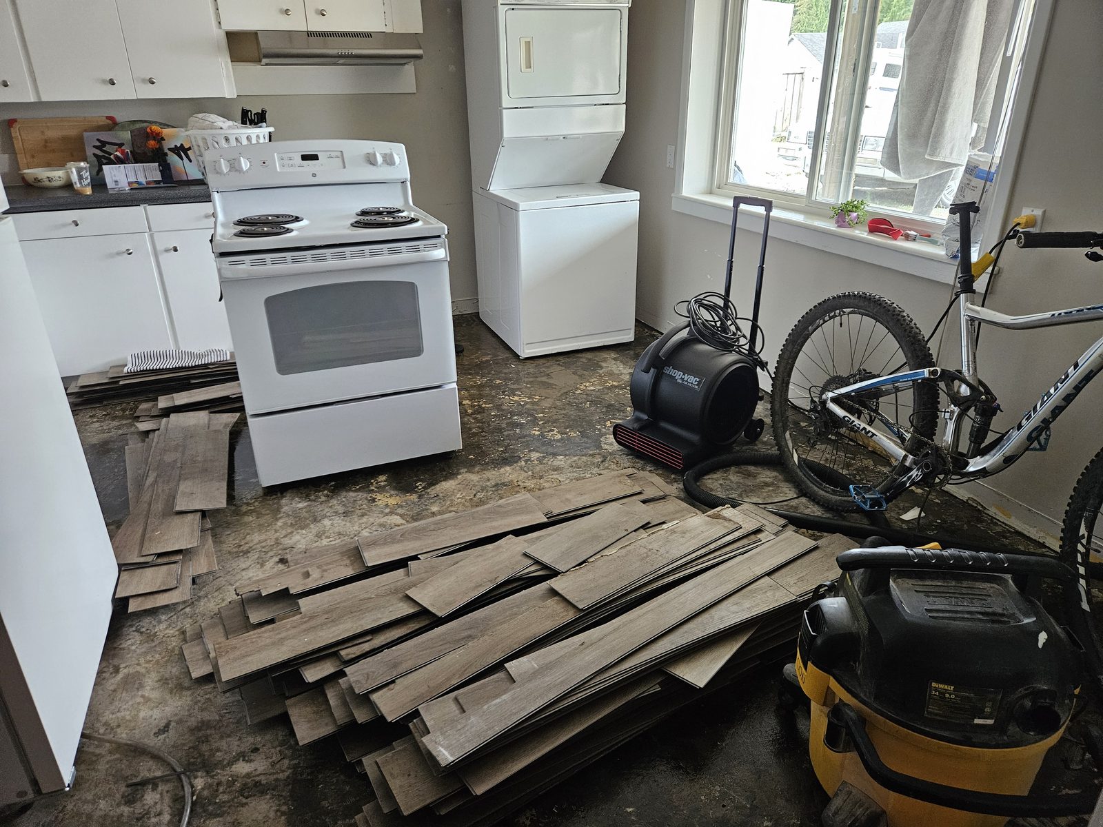 Flooring lifted and drying equipment set up in a flooded kitchen